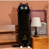 Plush Black Cat 70CM standing next to a table lamp in a cozy room setting.